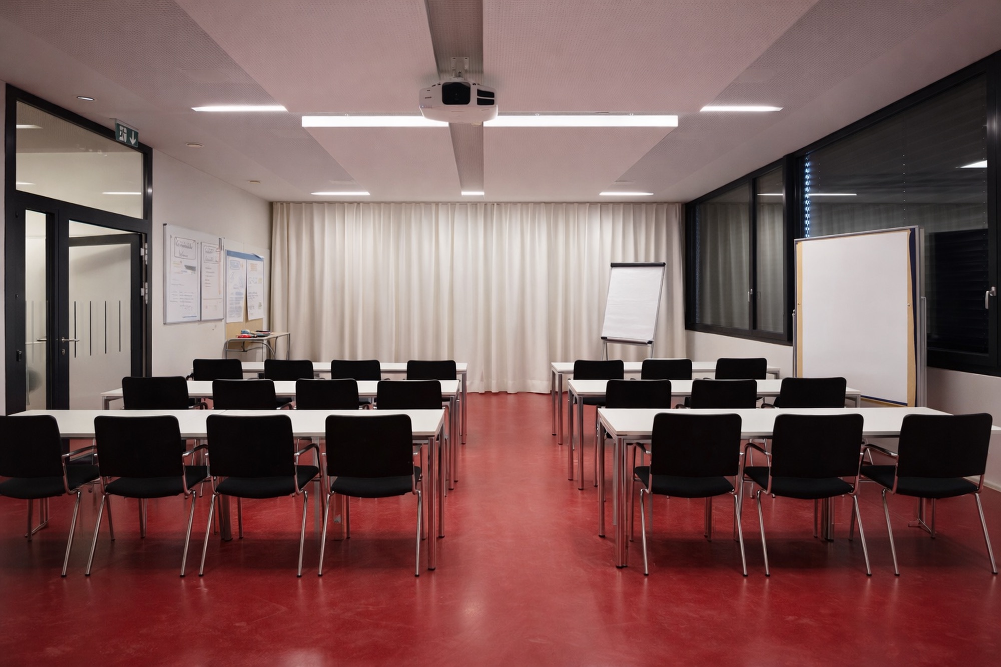 Schulungsraum mit Tischen. Akustikvorhang und Deckenabsorber für bessere Verständlichkeit